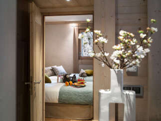 This charming chalet bedroom features twin beds with plush bedding, creating a cozy and inviting atmosphere.