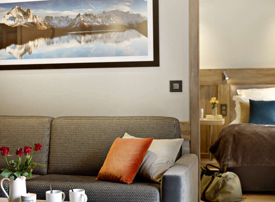 Relax in this cozy living room featuring a comfortable sofa, a rustic coffee table, and a stunning mountain landscape print.