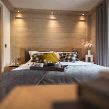 This luxurious bedroom boasts a stunning wood-paneled wall, creating a warm and inviting atmosphere.
