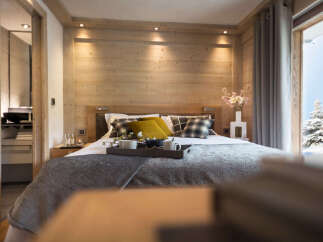 This luxurious bedroom boasts a stunning wood-paneled wall, creating a warm and inviting atmosphere.