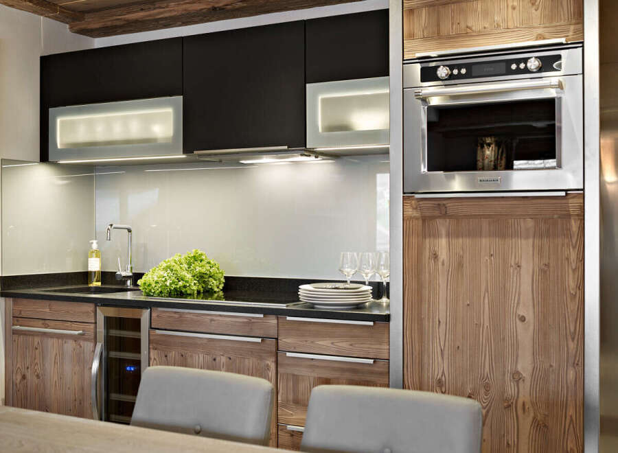 This stunning kitchen boasts sleek black cabinetry contrasted by warm wood accents, creating a sophisticated and inviting atmosphere.
