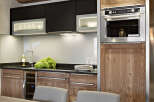 This stunning kitchen boasts sleek black cabinetry contrasted by warm wood accents, creating a sophisticated and inviting atmosphere.