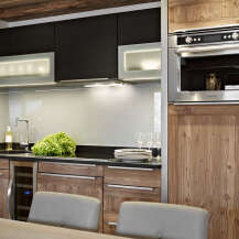 This stunning kitchen boasts sleek black cabinetry contrasted by warm wood accents, creating a sophisticated and inviting atmosphere.