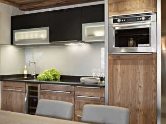 This stunning kitchen boasts sleek black cabinetry contrasted by warm wood accents, creating a sophisticated and inviting atmosphere.