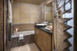 This luxurious bathroom boasts a spacious bathtub, a sleek modern sink, and plenty of storage space.