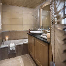 This luxurious bathroom boasts a spacious bathtub, a sleek modern sink, and plenty of storage space.