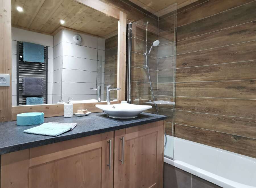This stunning bathroom boasts a modern design with a sleek, square sink and a walk-in shower with glass enclosure.