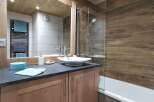 This stunning bathroom boasts a modern design with a sleek, square sink and a walk-in shower with glass enclosure.