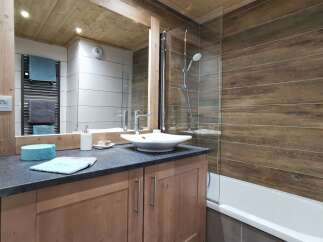 This stunning bathroom boasts a modern design with a sleek, square sink and a walk-in shower with glass enclosure.