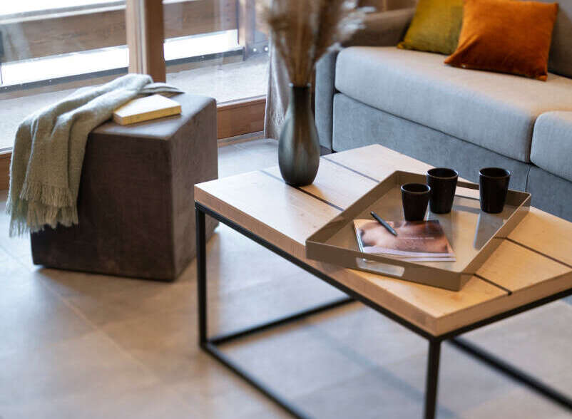 Modern living room with a light grey sofa, wooden coffee table, and stylish decor.