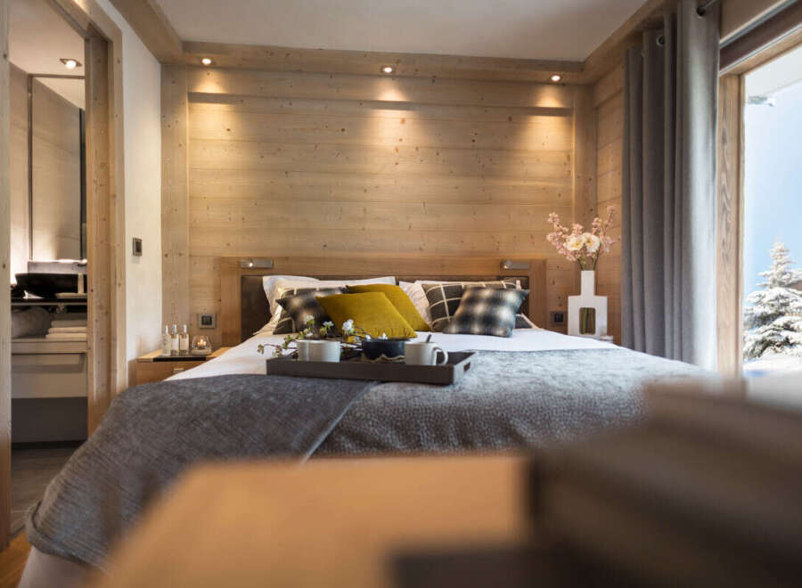 This luxurious bedroom boasts a stunning wood-paneled wall, creating a warm and inviting atmosphere.
