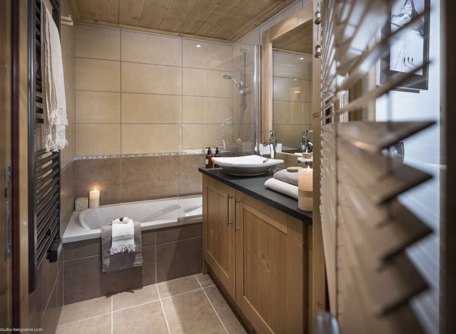 This luxurious bathroom boasts a spacious bathtub, a sleek modern sink, and plenty of storage space.
