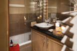 This luxurious bathroom boasts a spacious bathtub, a sleek modern sink, and plenty of storage.