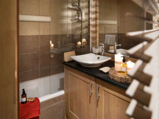 This luxurious bathroom boasts a spacious bathtub, a sleek modern sink, and plenty of storage.