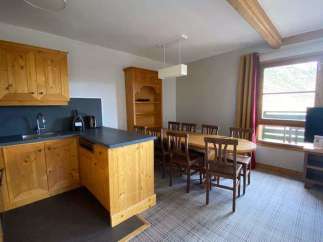 This charming property features a well-equipped kitchen with wooden cabinetry and a sleek countertop.