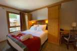 Cozy up in this charming bedroom featuring a comfortable bed and inviting decor.