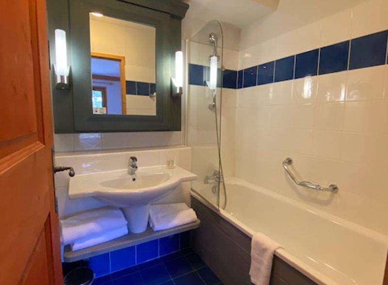 Discover a stylish bathroom featuring a sleek sink, a relaxing bathtub, and a modern shower.