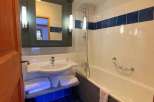 Discover a stylish bathroom featuring a sleek sink, a relaxing bathtub, and a modern shower.