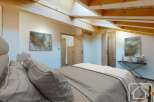Experience the charm of this stunning bedroom, featuring a unique wooden beam ceiling and a modern design.