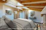 Discover the charm of this stunning bedroom, featuring exposed wooden beams and a unique architectural design.