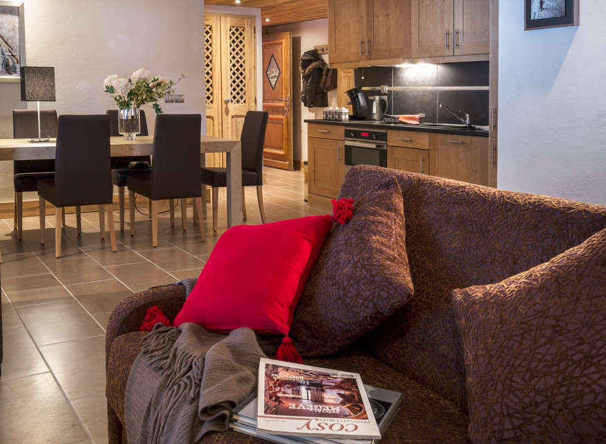 This stunning apartment boasts an open-plan living area with a comfortable couch and a dining area perfect for family meals.