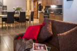 This stunning apartment boasts an open-plan living area with a comfortable couch and a dining area perfect for family meals.
