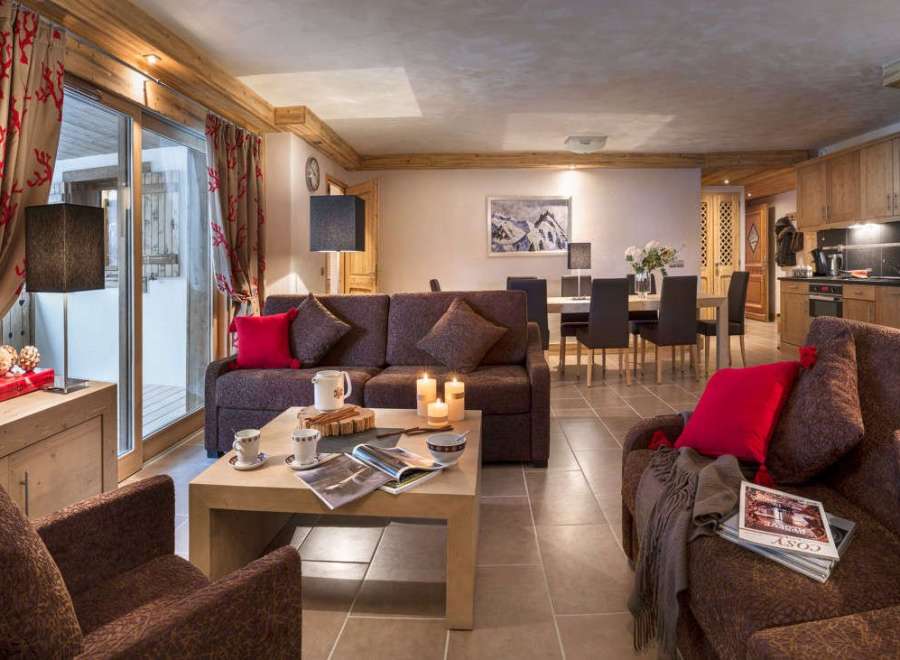 This stunning apartment boasts a spacious living area with comfortable sofas, a cozy fireplace, and large windows offering ample natural light.