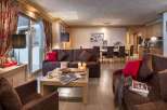 This stunning apartment boasts a spacious living area with comfortable sofas, a cozy fireplace, and large windows offering ample natural light.
