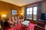 Cozy living room with a vibrant red patterned carpet and a comfortable plaid sofa.