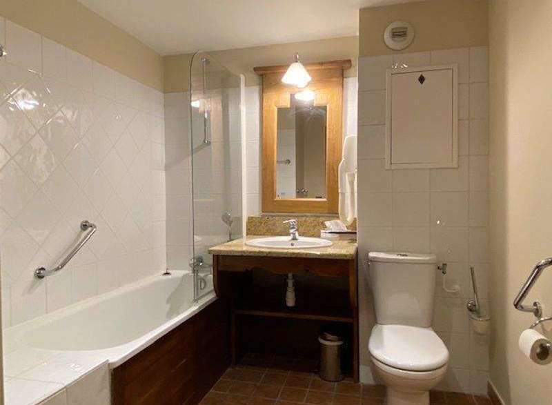This bathroom features a classic design with a bathtub and a separate toilet area.