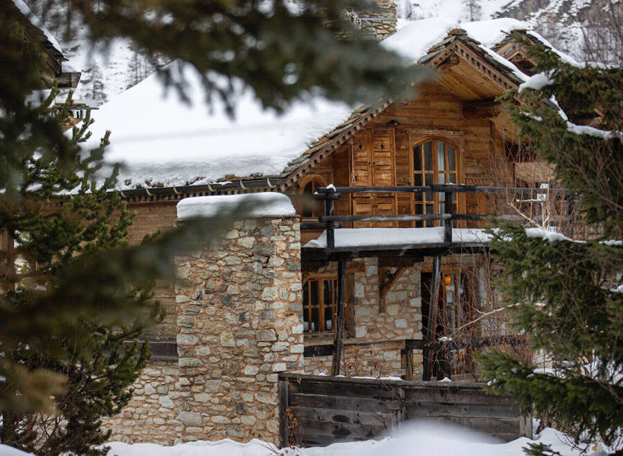 Discover the charm of this stunning wooden chalet nestled in a snowy landscape.