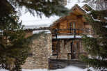 Discover the charm of this stunning wooden chalet nestled in a snowy landscape.