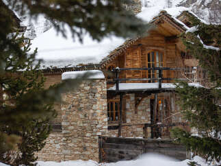 Discover the charm of this stunning wooden chalet nestled in a snowy landscape.