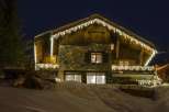 This stunning chalet boasts a beautiful stone and wood exterior, illuminated by charming icicle lights.