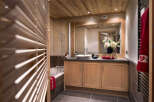 This stunning bathroom boasts a spacious design with light wood cabinets and a walk-in shower.