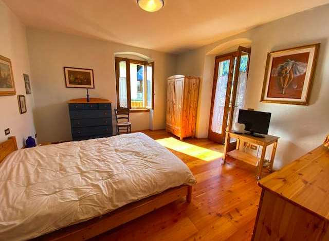 Discover a charming bedroom with a cozy bed and warm wooden floors.