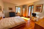 Discover a charming bedroom with a cozy bed and warm wooden floors.