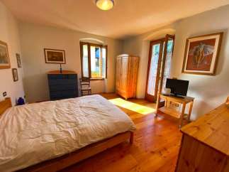 Discover a charming bedroom with a cozy bed and warm wooden floors.