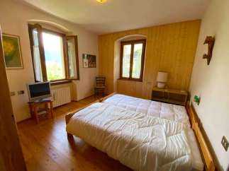 Cozy bedroom with natural light and wooden floors.
