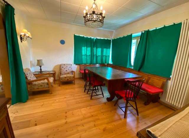 This charming property features a cozy dining area with a large wooden table and comfortable seating.