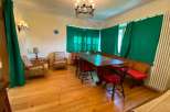 This charming property features a cozy dining area with a large wooden table and comfortable seating.