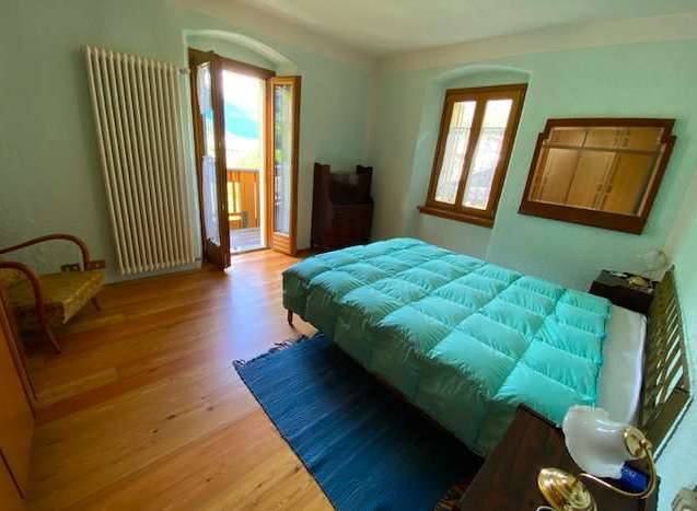 This charming bedroom features a cozy bed with a plush, turquoise comforter, perfect for a relaxing stay.