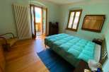 This charming bedroom features a cozy bed with a plush, turquoise comforter, perfect for a relaxing stay.