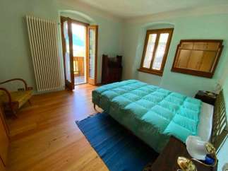 This charming bedroom features a cozy bed with a plush, turquoise comforter, perfect for a relaxing stay.
