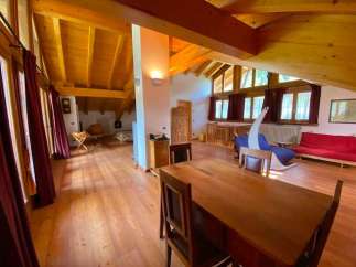 This stunning property boasts a spacious, light-filled interior with exposed wooden beams and a warm, inviting atmosphere.