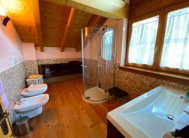 This charming bathroom features a unique wooden ceiling and flooring, creating a warm and inviting atmosphere.