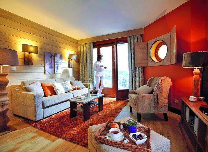 Experience the cozy charm of this inviting living space, featuring warm wooden accents and a plush sofa perfect for relaxation.