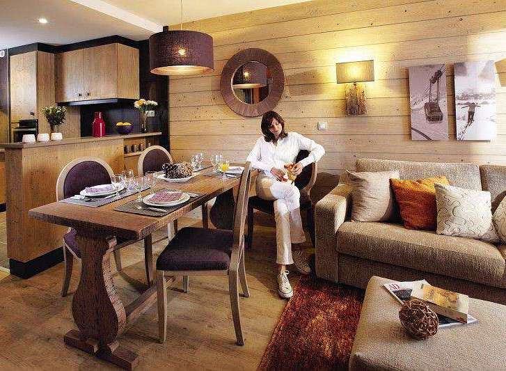 Experience cozy living in this charming property, featuring a rustic wooden dining table perfect for intimate meals.