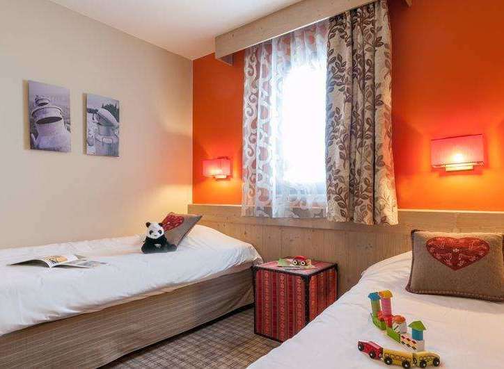 This cozy bedroom features two twin beds, perfect for a comfortable stay.