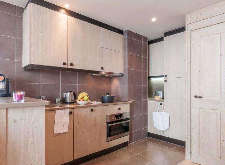 This charming kitchen boasts a modern design with light wood cabinetry and sleek appliances.